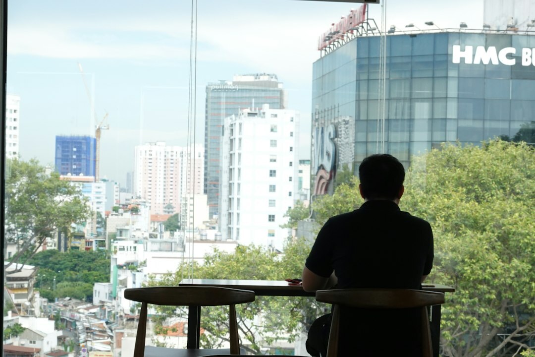 Person writing notes by a window with coffee